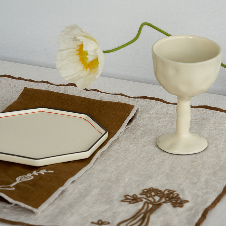 Black Blaze Gem side dish in ivory on a place mat and featuring the drift goblet available from Shop Dessein Parke