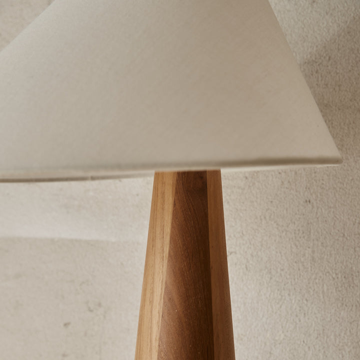 Table lamp with a wooden base by McMullin featuring a light-colored lampshade and natural wood grain.