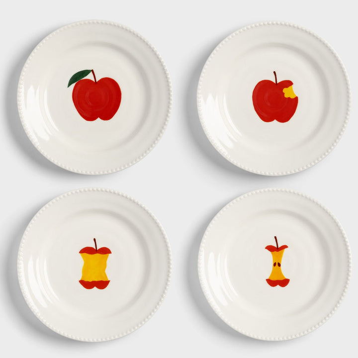 Set of four white plates with hand-painted apple designs by &Klevering, showing a progression from whole to core.
