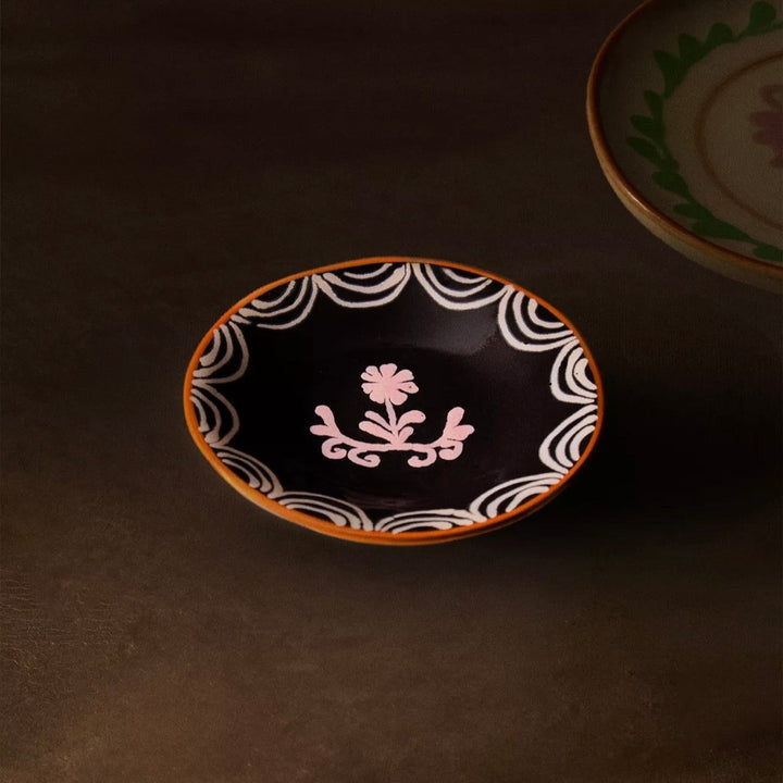 Decorative ceramic plate with floral design on a dark surface