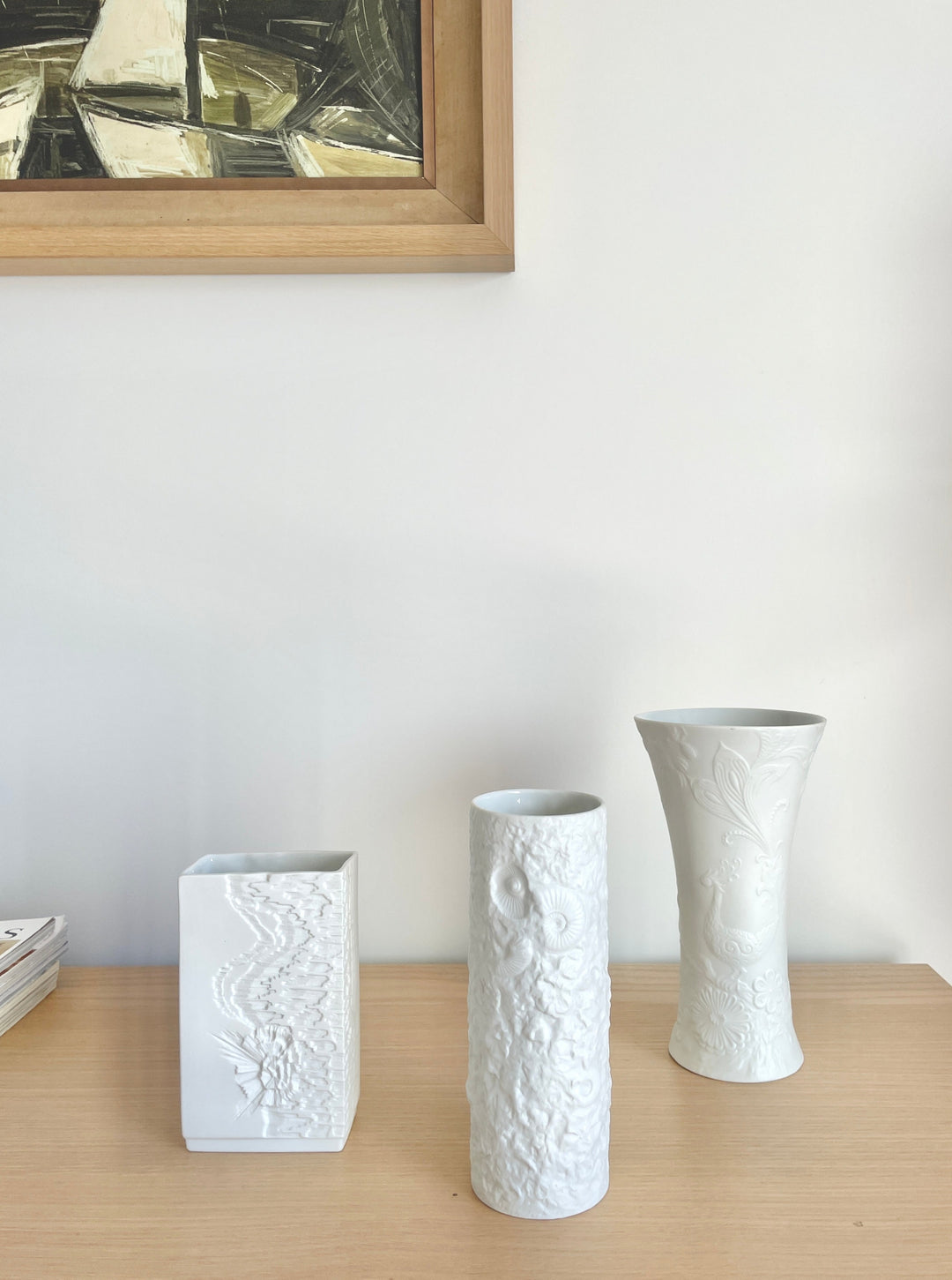 White porcelain vase by Kaiser, showcasing a bisque finish and embossed details of floral and geometric motifs.