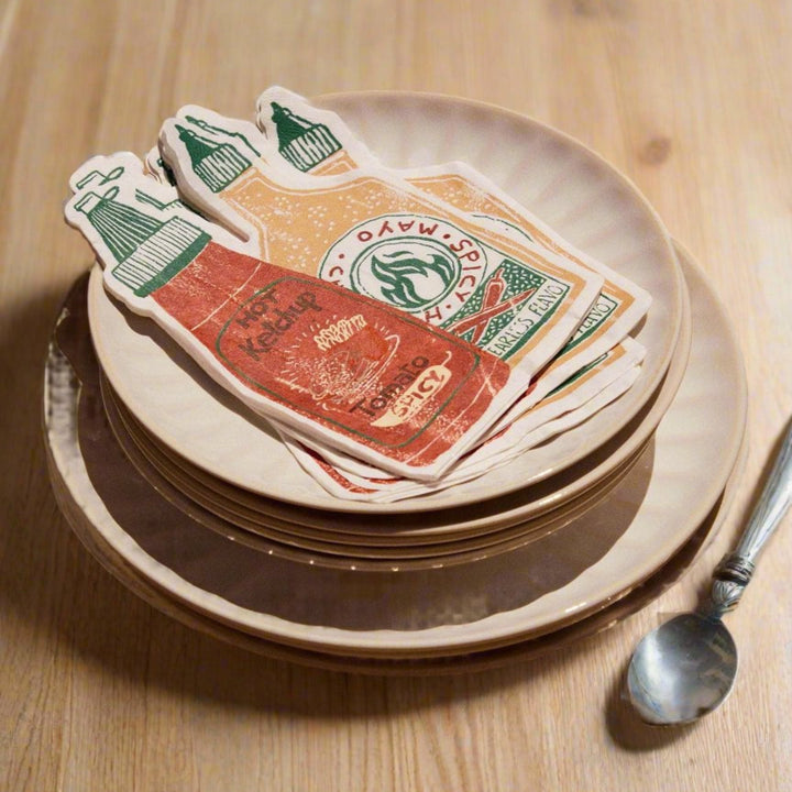 Sauces paper napkins pack of twenty with ketchup and mayonnaise prints on stacked plates.