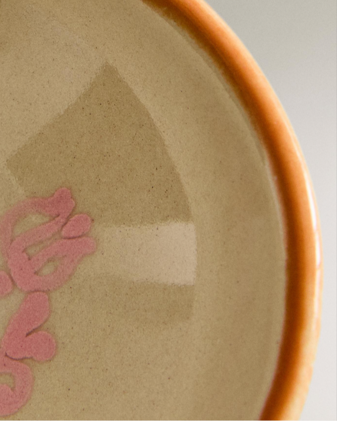 Painted earthware mini bowl with pink floral design, by Nanushka, featuring tan and beige square accents.