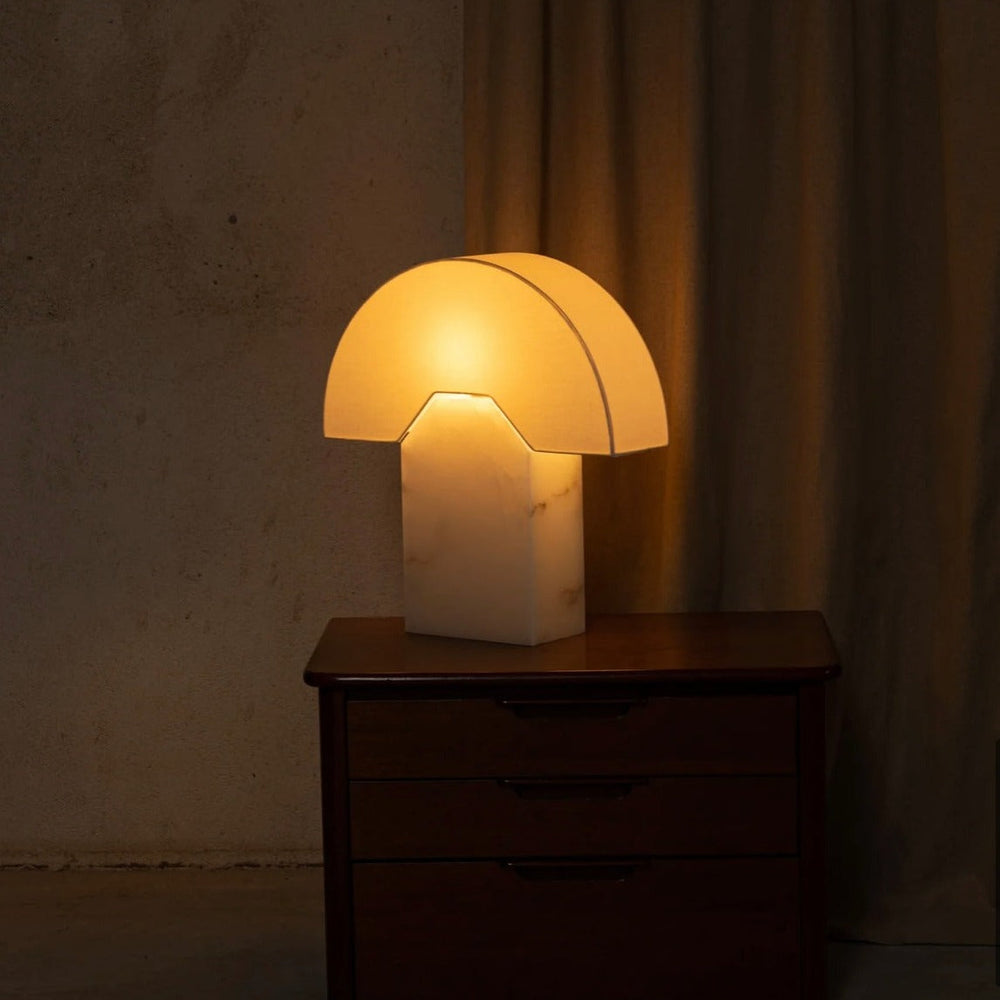 Alabaster table lamp from Simone and Marcel, illuminating a bedside table.
