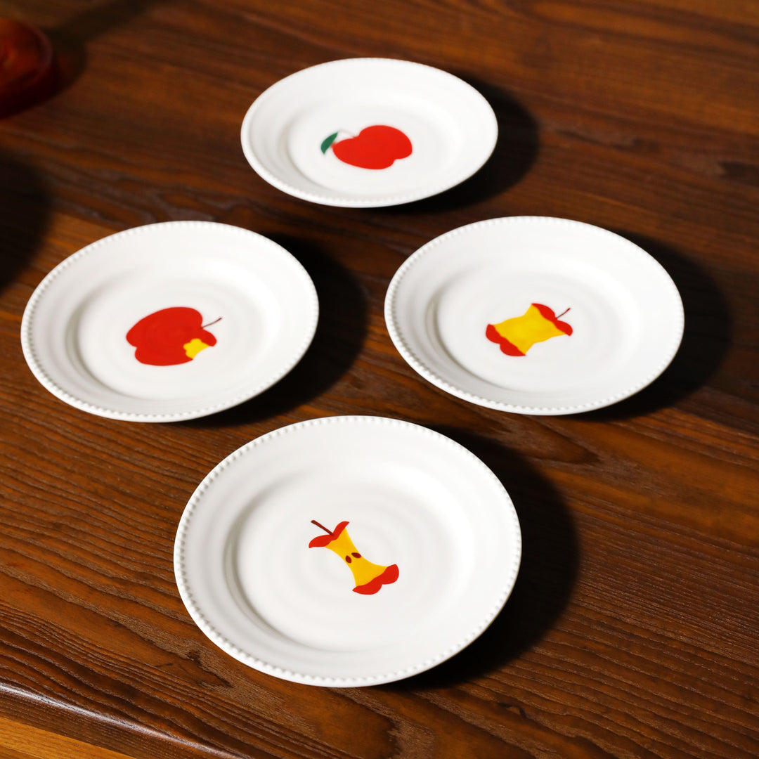 White Haines Apple plates set by &klevering, depicting various stages of an eaten apple.