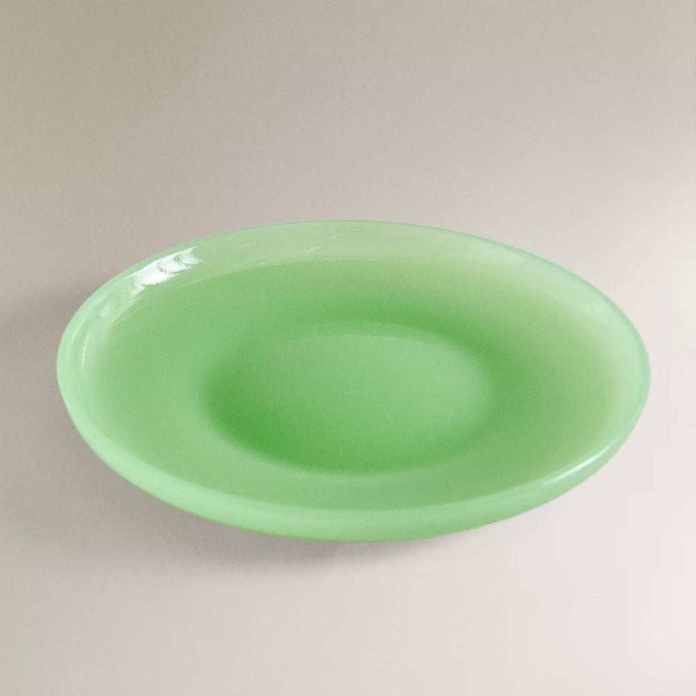 Green dinner plate by Nanushka with a smooth, rounded surface.