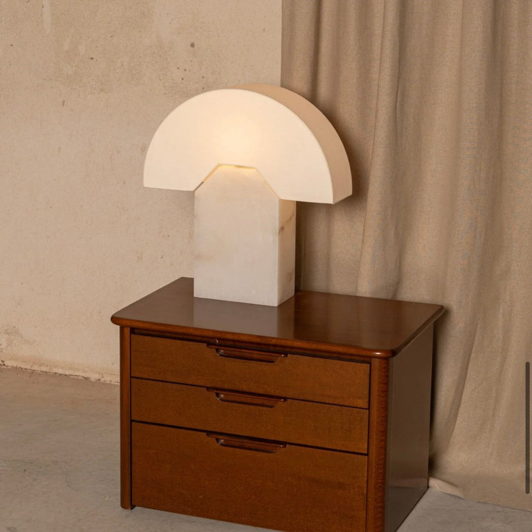 Alabaster table lamp, Edna model by Simone and Marcel, sitting on a dark wood nightstand.