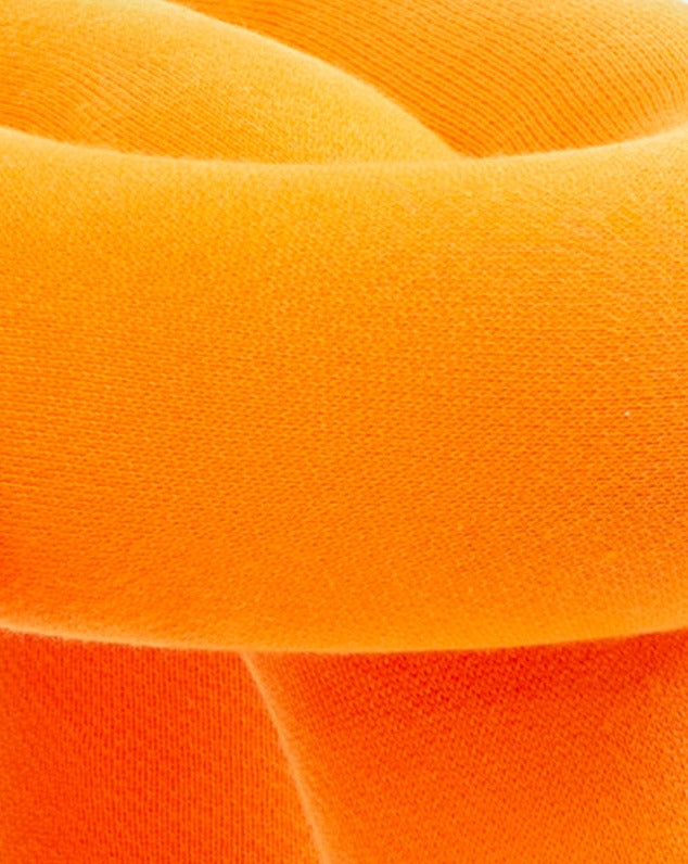 Orange knitted stool by Moustache, featuring a twisted design with a soft, textured appearance.