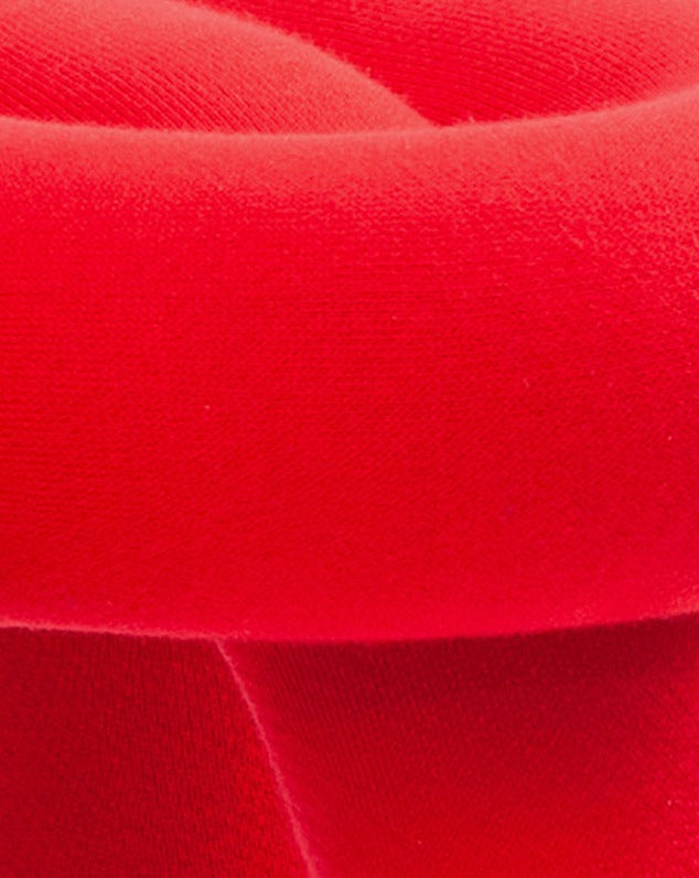 Red cushioned stool with a curved design.