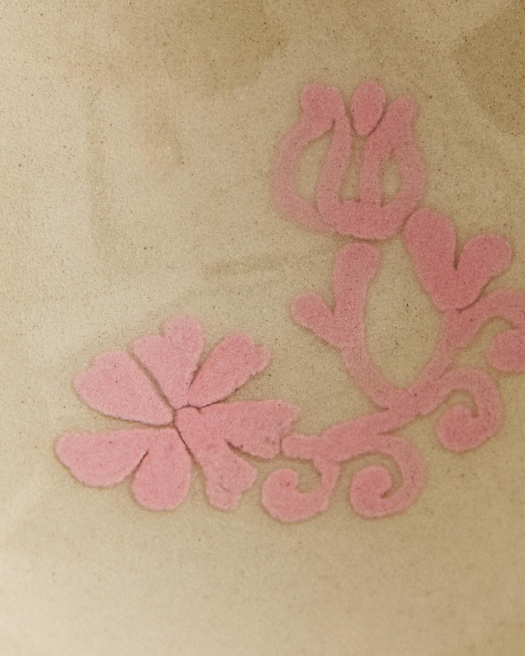 Painted earthware mini bowl from Nanushka, featuring a delicate pink floral design in a light brown color.