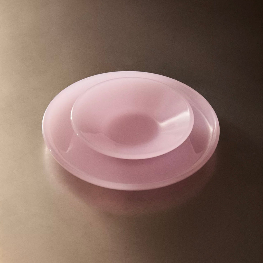 Pink dinner plate by Nanushka, displayed on a metallic surface.
