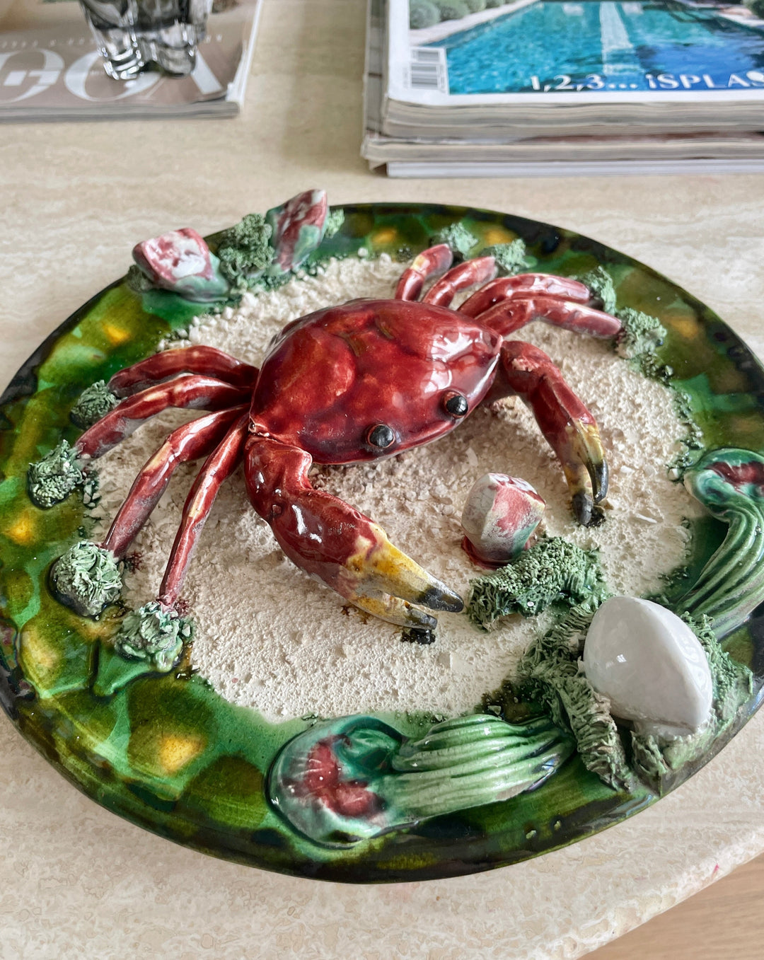 Decorative Majolica Palissy ware crab plate from the 1940s featuring a glazed red crab on a sand textured background.