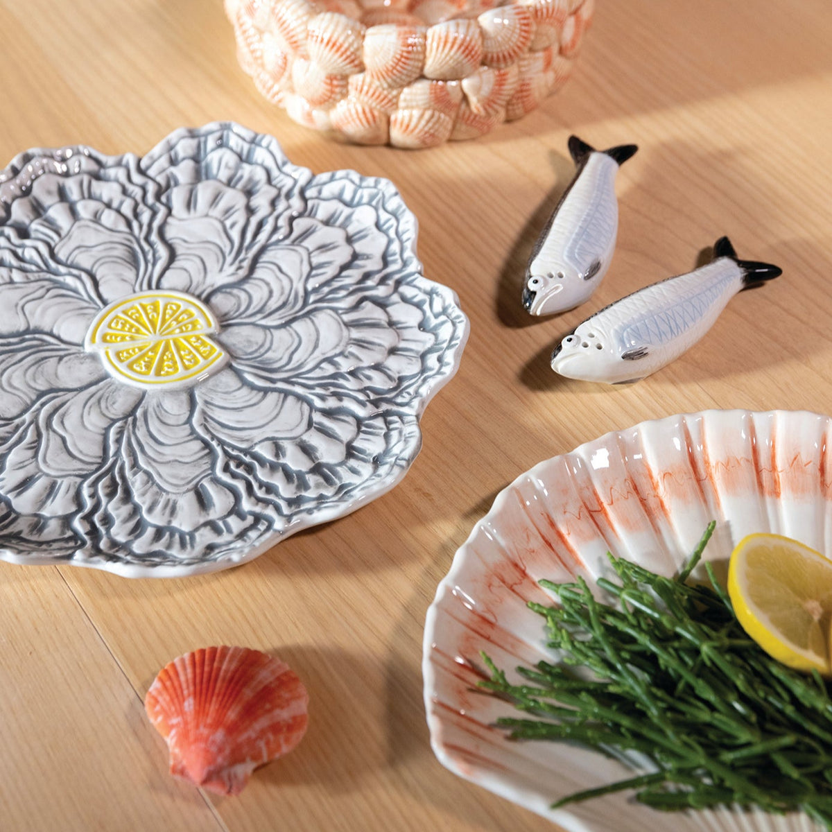 Decorative oyster plate by &Klevering with gray oyster pattern and a yellow lemon in the center.