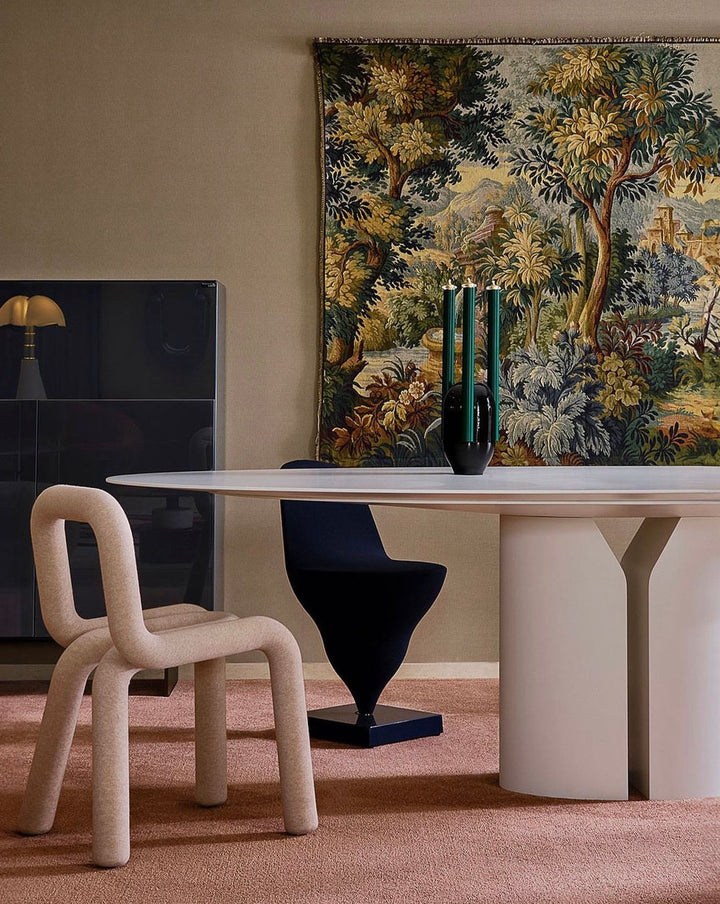 Grey Moustache Paris Bold Chair with a sculptural, tubular design, placed on a pink rug in a stylized interior.
