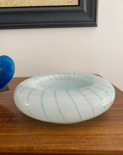 Circular Murano blue and white swirled glass bowl on wooden sideboard