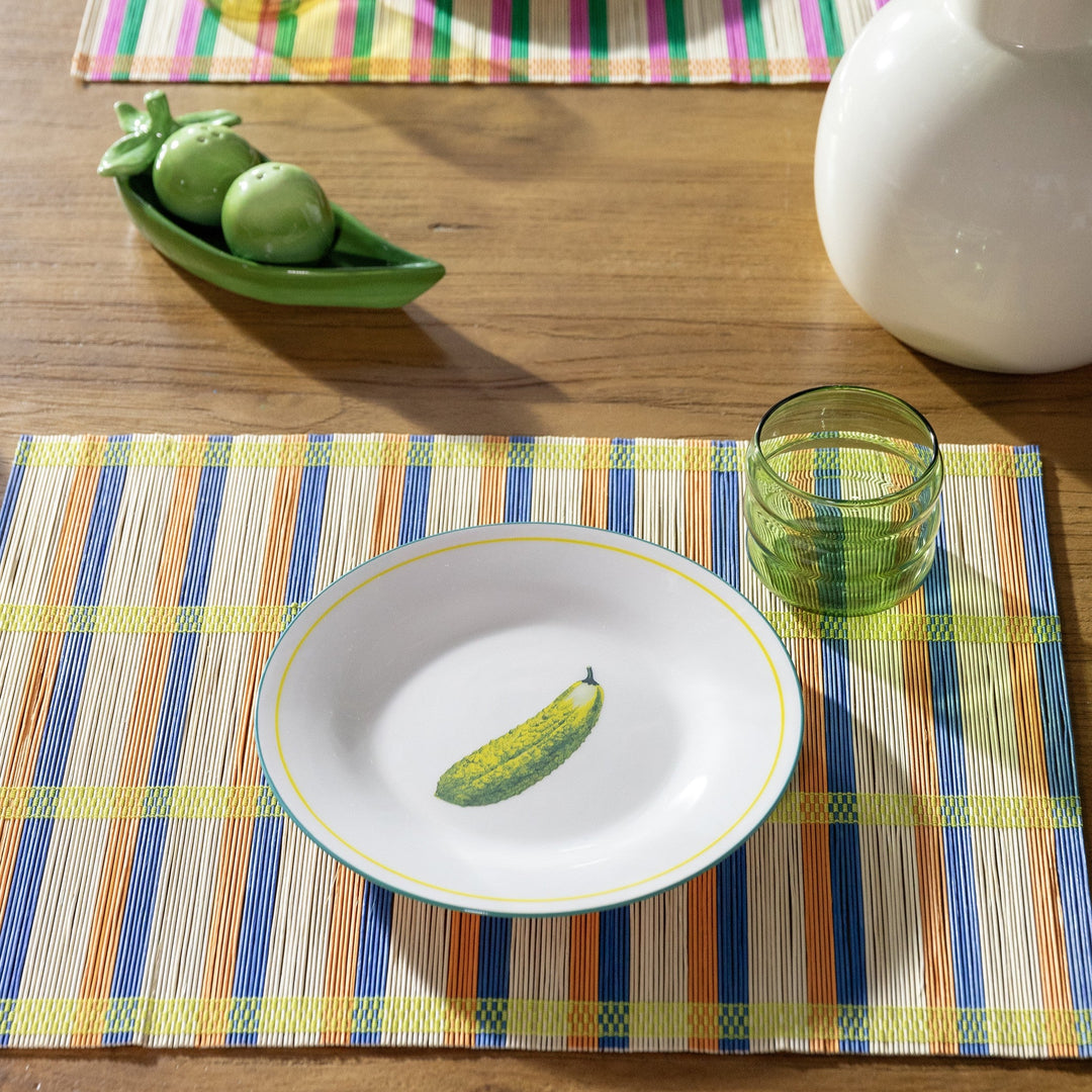 Green pea-shaped salt and pepper shaker set by &klevering, displayed on a wooden table near a white vase.