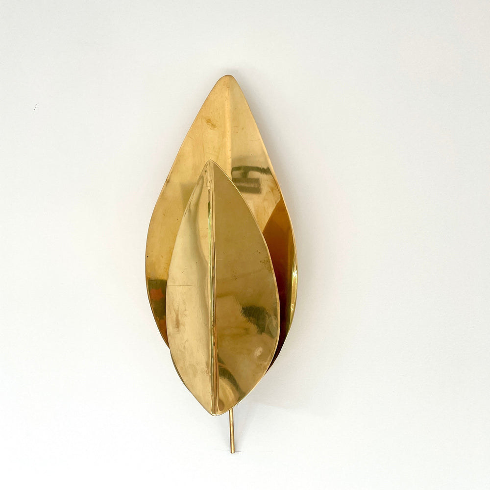 Gold metal leaf wall lights by Tomasso Barbi, with a sculptural, layered design and sleek reflective finish.
