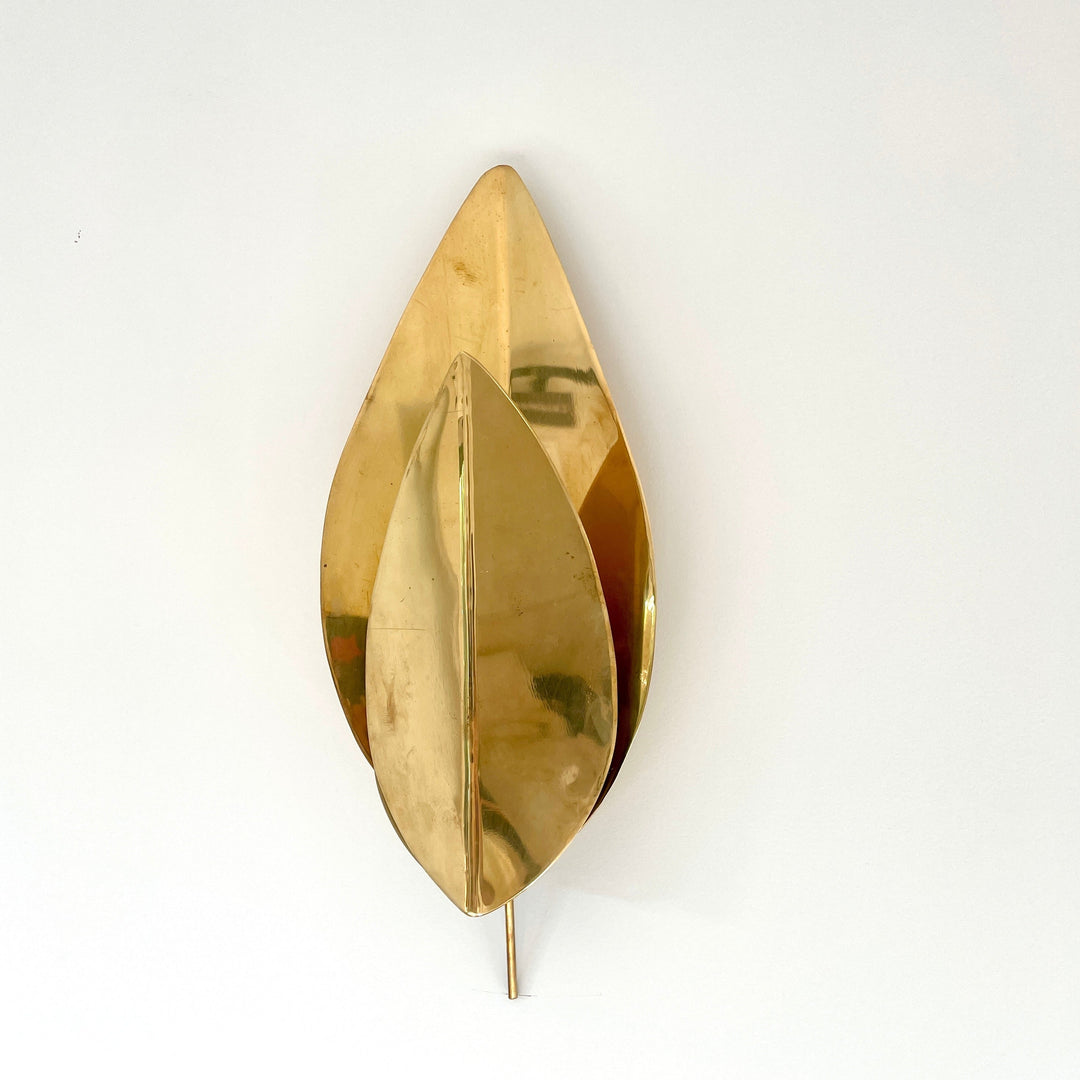 Gold metal leaf wall lights by Tomasso Barbi, with a sculptural, layered design and sleek reflective finish.
