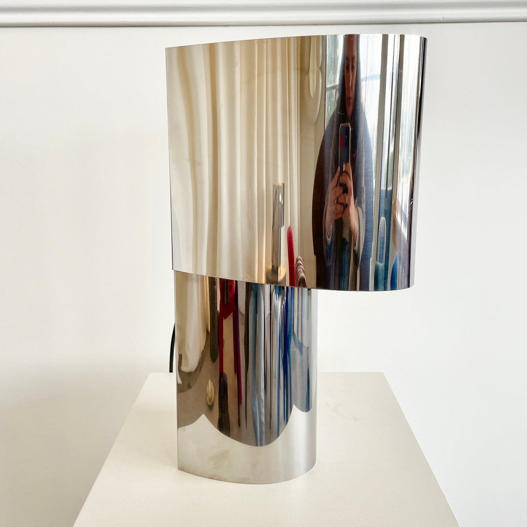 Stainless steel wall or table light from the 1970s, reflecting a room and person taking a picture.