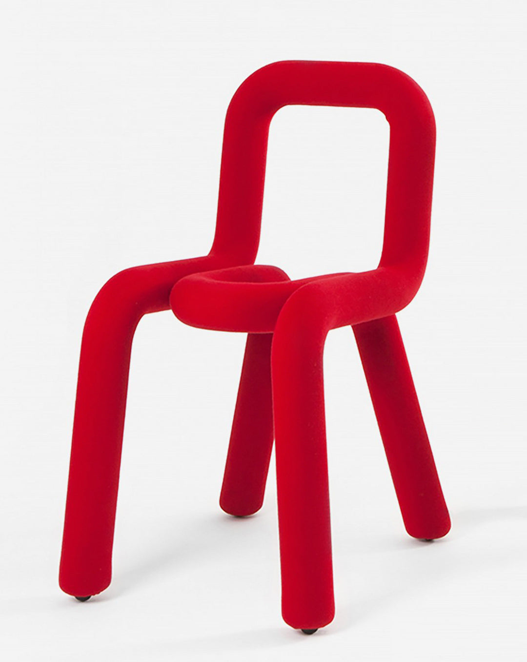 Red velvet chair by Moustache Paris with a rounded square back and legs.