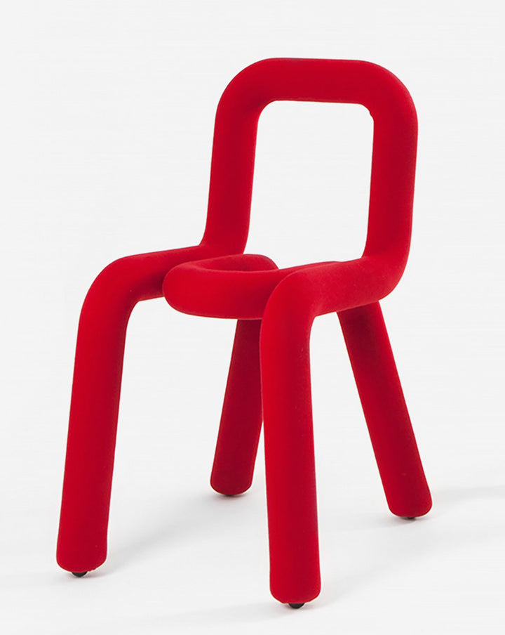 Red velvet chair by Moustache Paris with a rounded square back and legs.