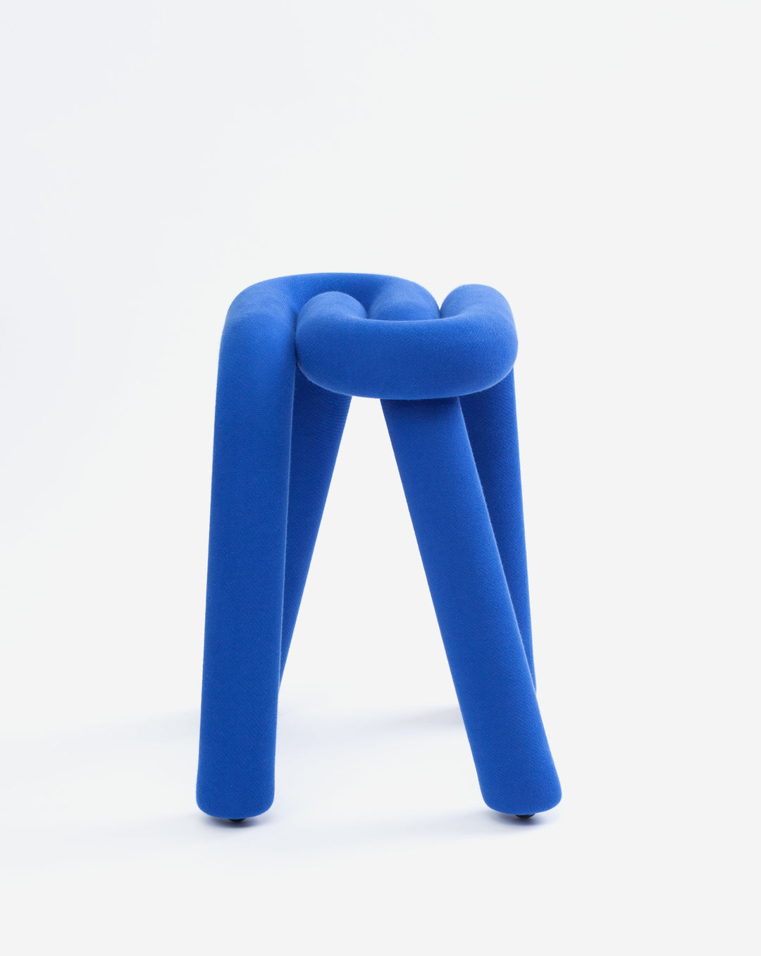 Blue upholstered stool by Moustache, featuring a knot design with cylindrical legs, on a white background.