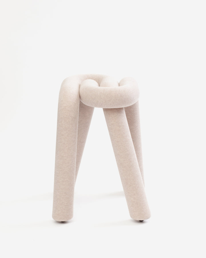 Beige knit stool from Moustache, featuring a looped seat and three cylindrical legs.