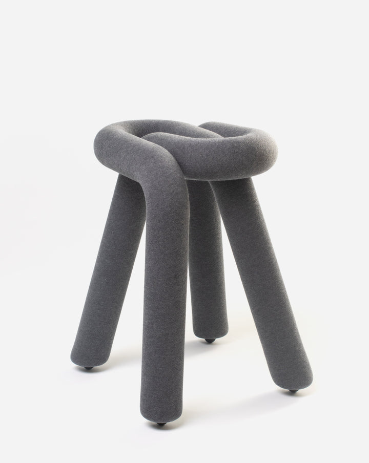 Gray upholstered stool by Moustache with a knotted design and three legs.