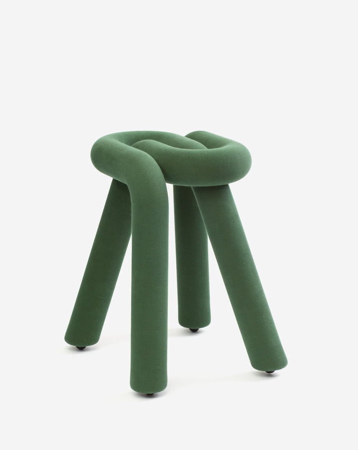 Green fabric stool by Moustache, featuring a knotted seat and cylindrical legs with dark feet, against a plain white background.