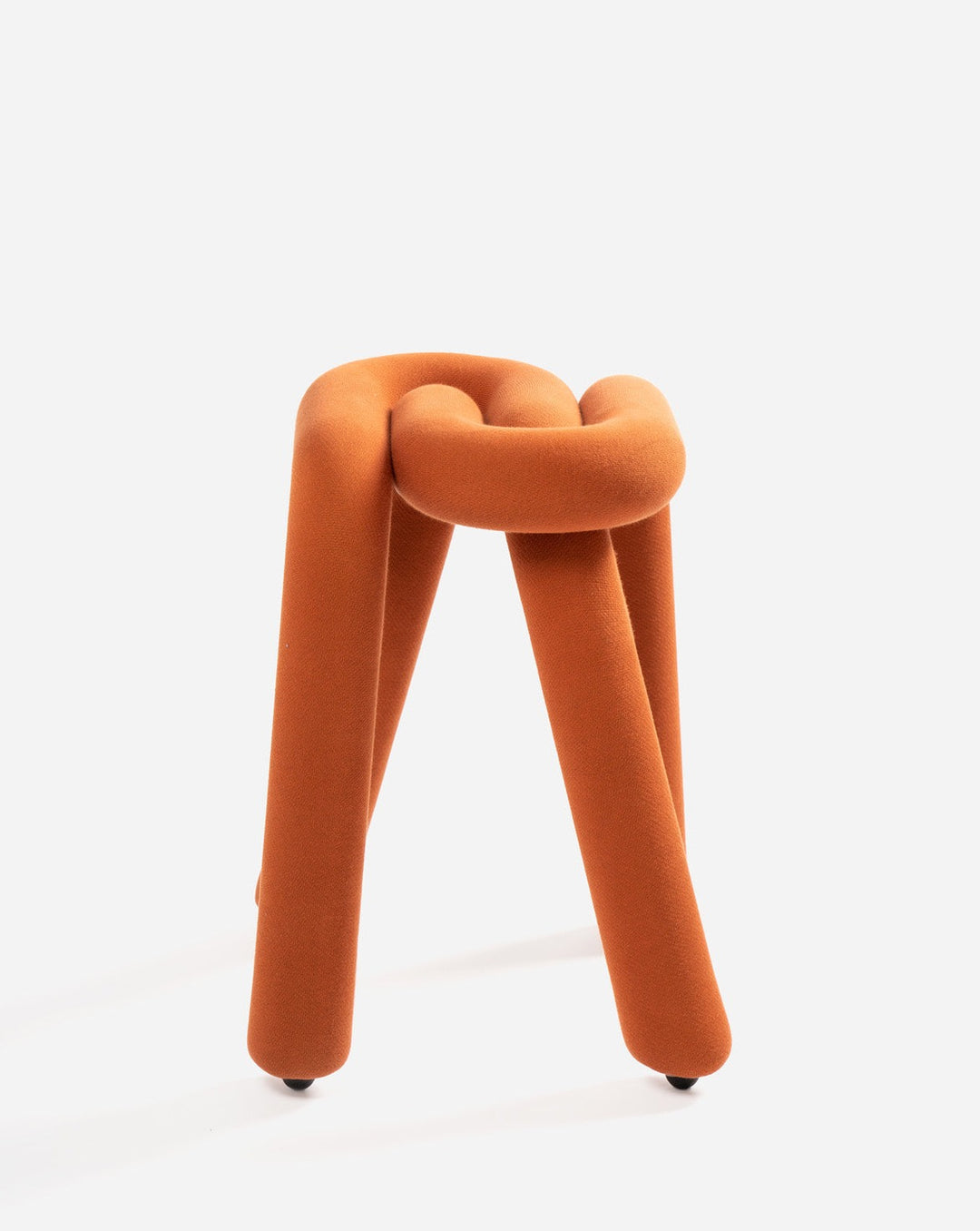 Orange fabric stool shaped like a knot with cylindrical legs.