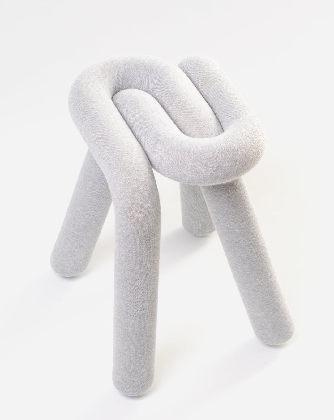Gray upholstered stool by Moustache with a knot-like design and rounded legs, shown against a white background.