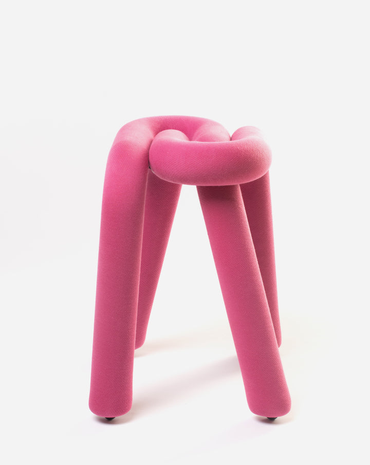 Purple stool by Moustache, featuring a twisted, knotted seat and three cylindrical legs with small rolling casters.