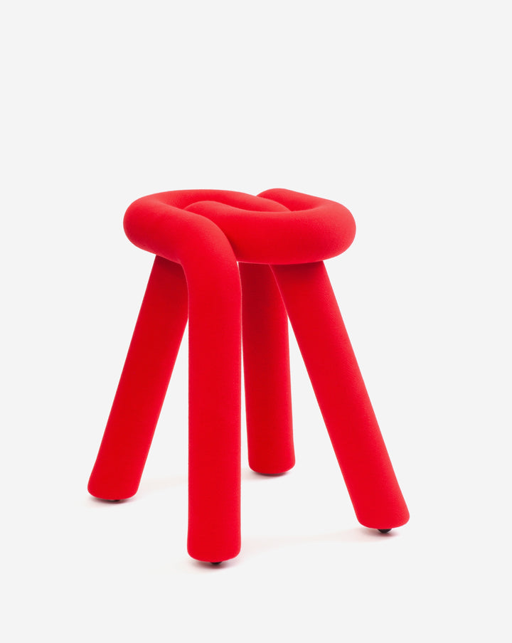 Red padded stool with three legs, designed by Moustache, featuring a knotted seat.