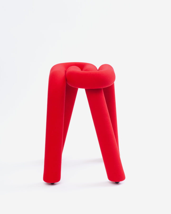 Red knotted stool with rounded legs on a white background.