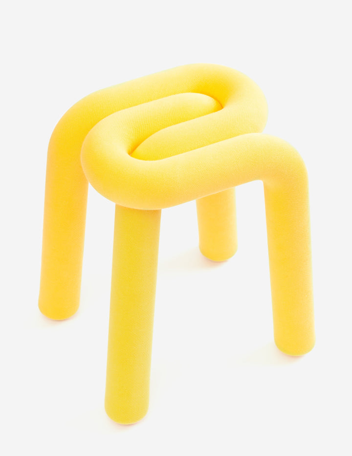 Yellow padded stool by Moustache, featuring a tubular, looping design and three legs.