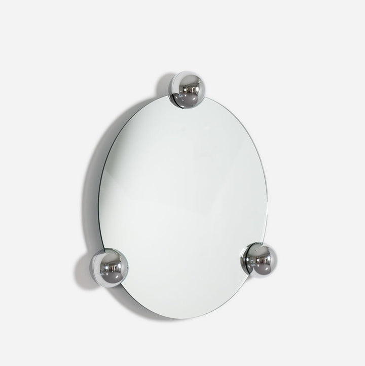 Round wall mirror by Moustache Paris with three chrome sphere accents.