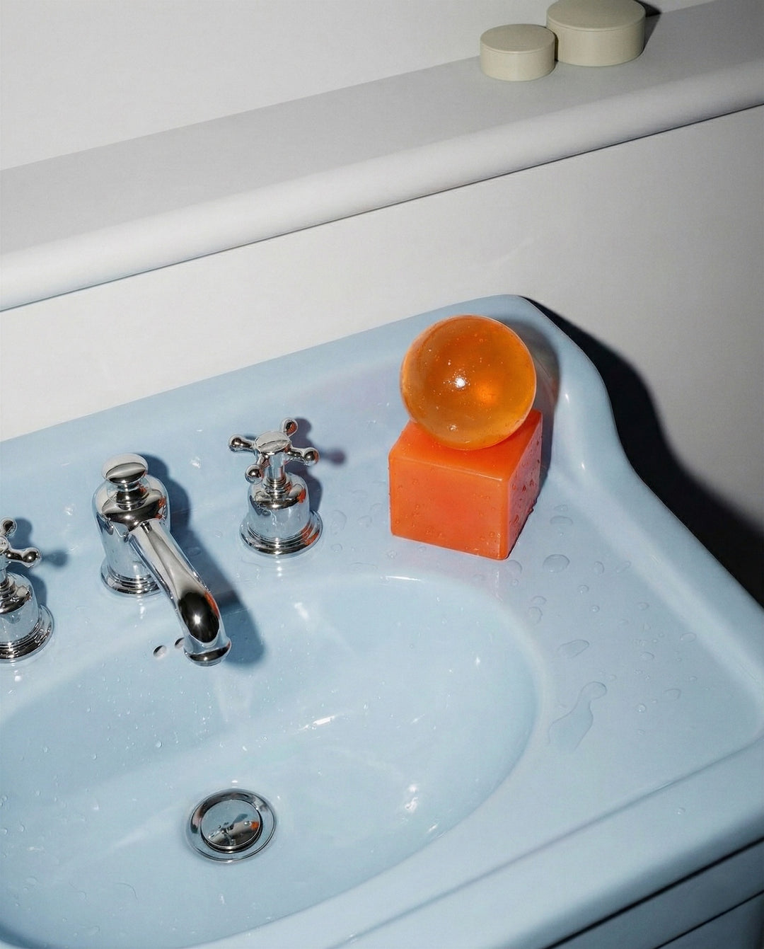 Orange soap on a blue sink with silver faucet