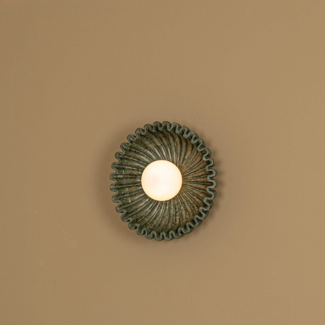 Green marble wall light by Simone and Marcel with a wavy edge and veined texture.
