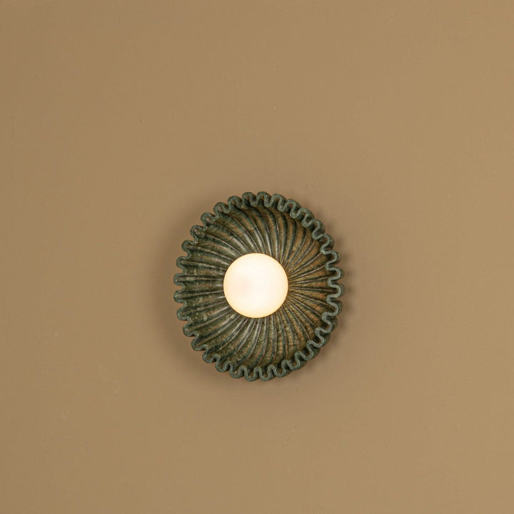 Green marble wall light by Simone and Marcel with a wavy edge and veined texture.