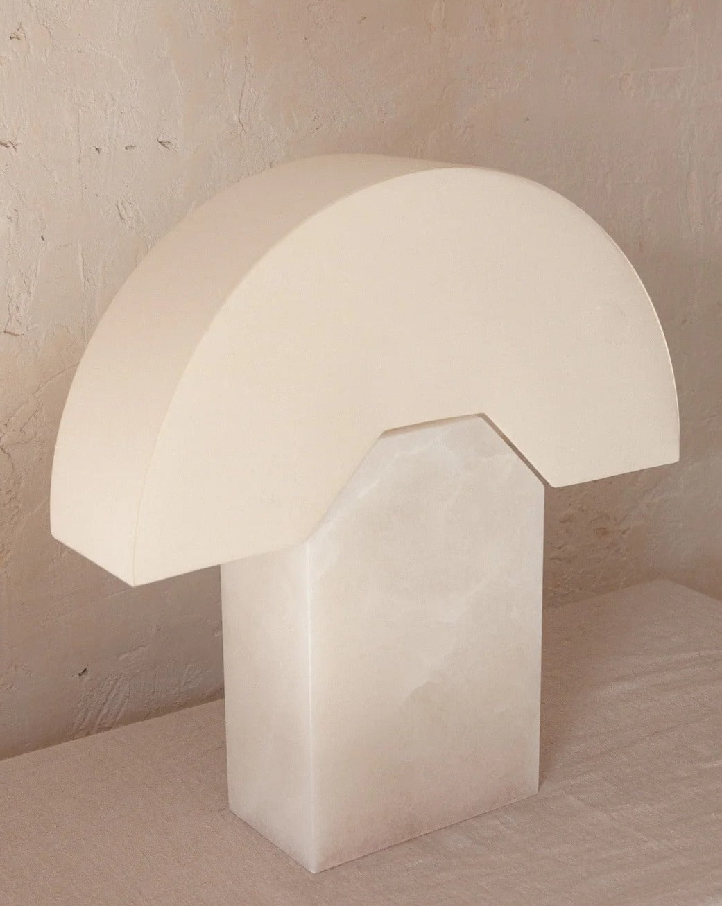 Alabaster table lamp from Simone and Marcel with a semi-circular shade and rectangular base.