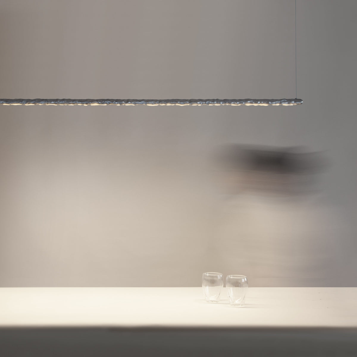 Aluminium linear ceiling light by Stem Design above a white bench