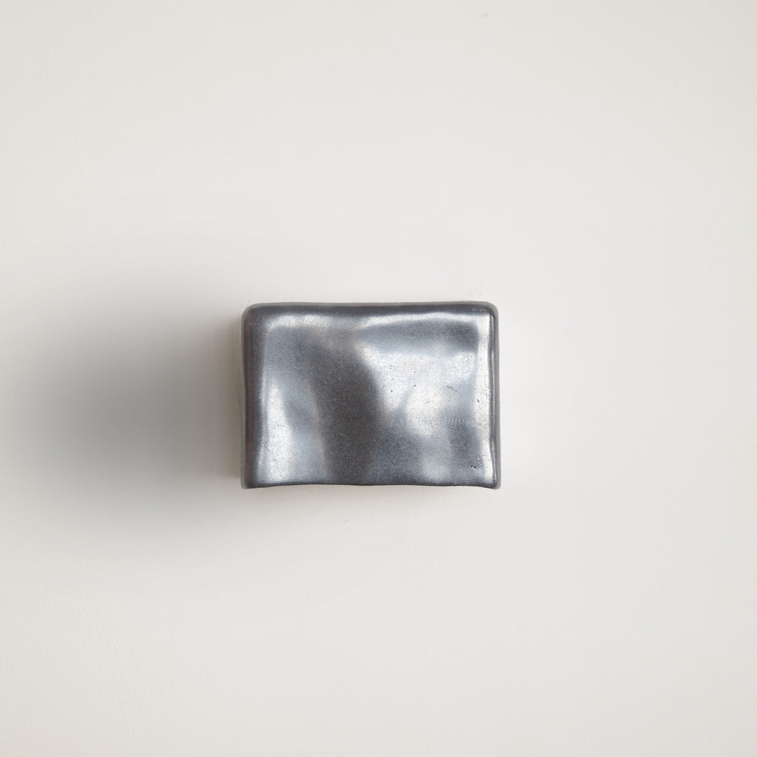 Metallic wall light by Stem Design on a light grey background