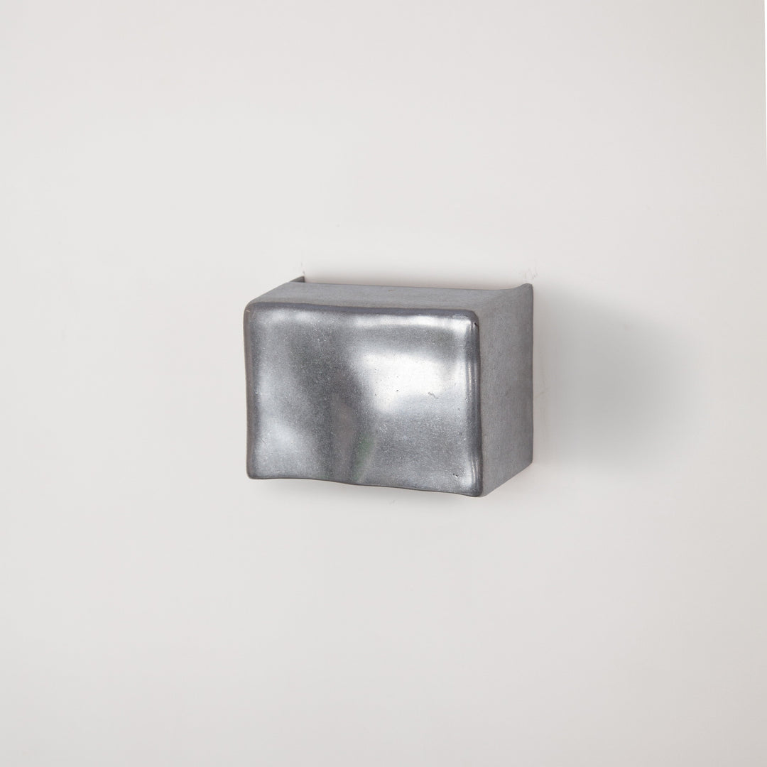 Metallic wall light by Stem Design on a light grey background