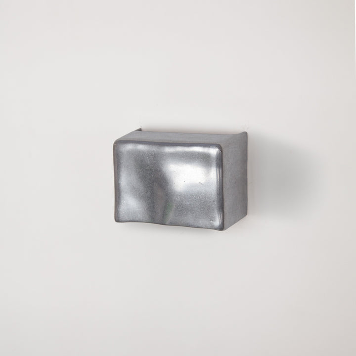 Metallic wall light by Stem Design on a light grey background