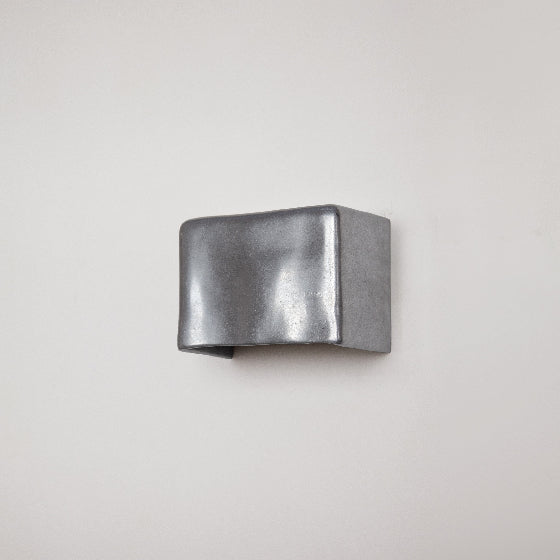 Metallic wall light by Stem Design on a light grey background