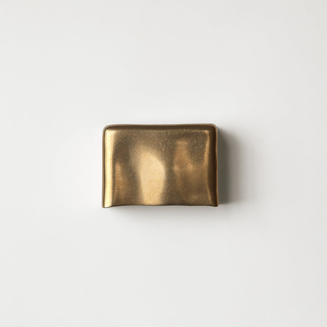 Brass wall light by Stem Design on a light grey background
