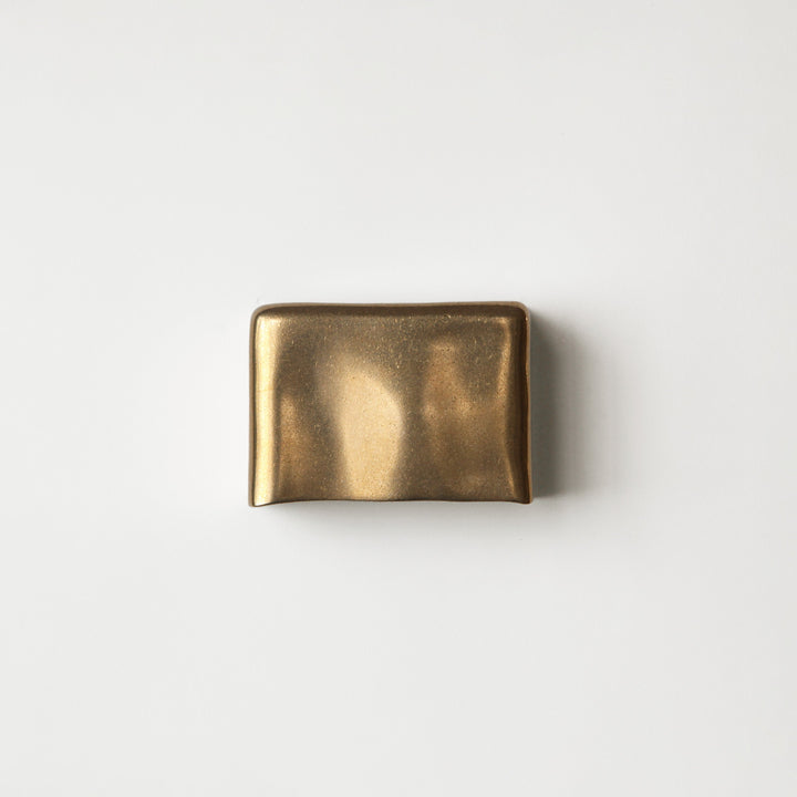 Brass wall light by Stem Design on a light grey background