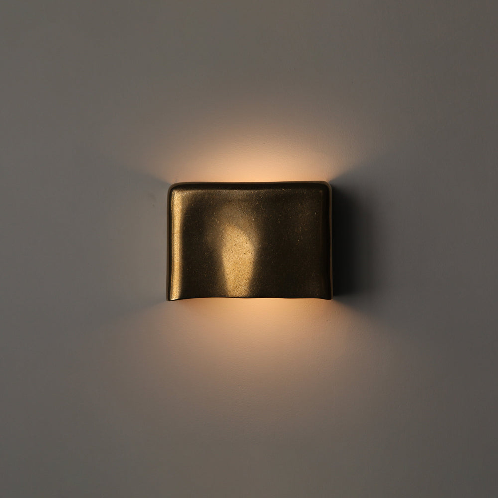 Brass wall light by Stem Design on a light grey background