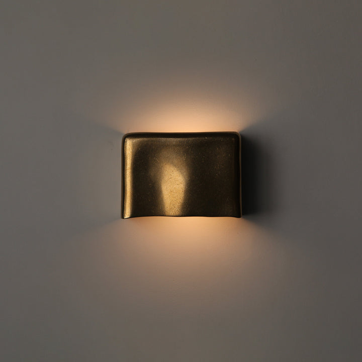 Brass wall light by Stem Design on a light grey background