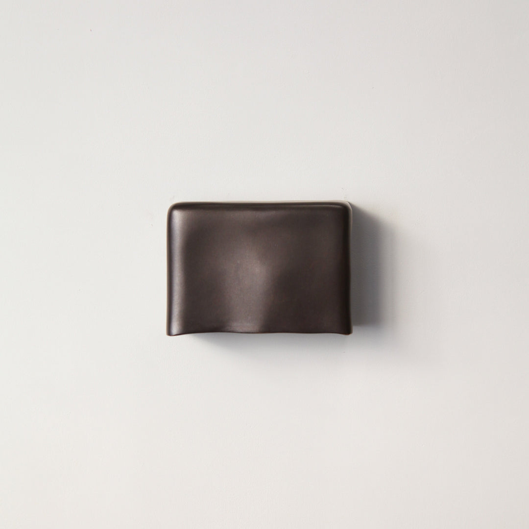 Darkened Brass wall light by Stem Design on a light grey background